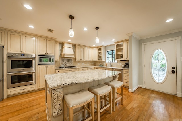 21221 Unicorn Ln, Roland, AR 72135 - kitchen featuring appliances with stainless steel finishes, custom range hood, backsplash, crown molding, and plenty of natural light