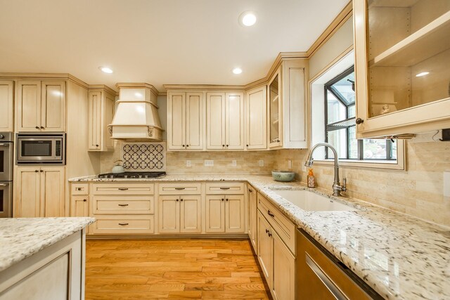 21221 Unicorn Ln, Roland, AR 72135 - kitchen with a sink, appliances with stainless steel finishes, custom exhaust hood, light wood-type flooring, and tasteful backsplash