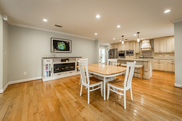 21221 Unicorn Ln, Roland, AR 72135 - dining area featuring crown molding, recessed lighting, baseboards, light wood-style floors, and a glass covered fireplace