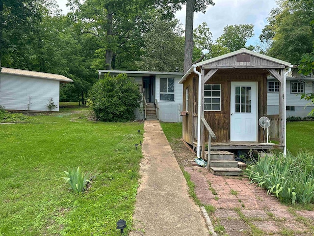 33 W Lakeshore Dr, Cherokee Village, AR 72529 - view of front of home with a front yard, entry steps, and an outdoor structure