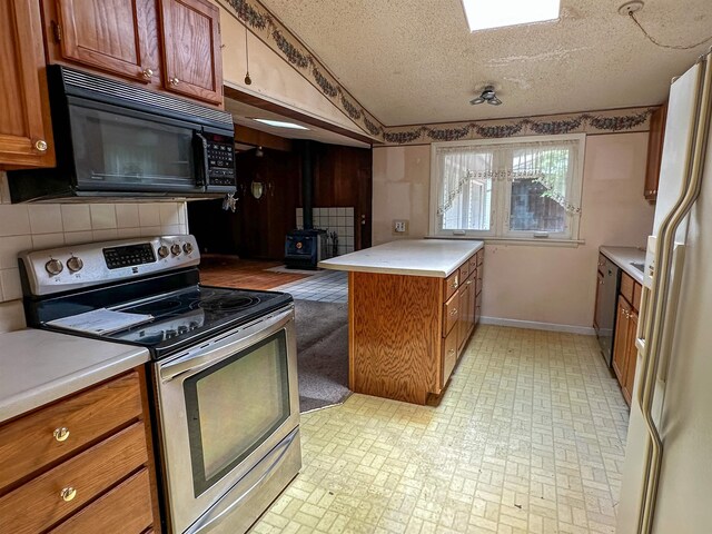 33 W Lakeshore Dr, Cherokee Village, AR 72529 - kitchen with electric stove, black microwave, a wood stove, freestanding refrigerator, and brown cabinets