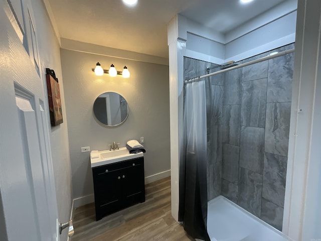 301 W Frazior, Linden, TX 75563 - full bathroom featuring vanity, wood finished floors, a tile shower, and baseboards