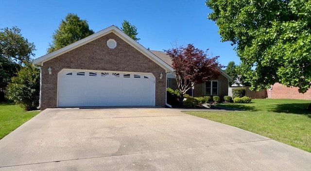view of front facade featuring brick siding, a front yard, driveway, and a garage