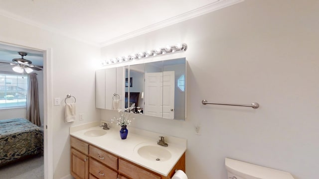 full bath with ensuite bathroom, toilet, double vanity, crown molding, and a ceiling fan