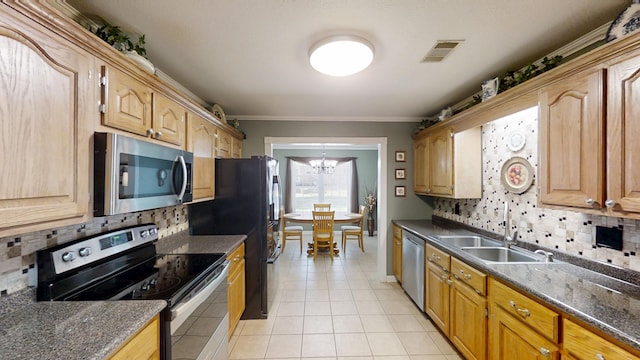 kitchen with stainless steel appliances, a sink, decorative backsplash, light tile patterned floors, and ornamental molding