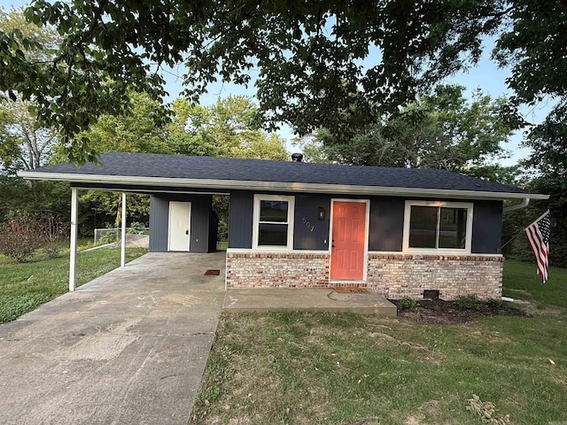 view of front of property with concrete driveway, brick siding, an attached carport, and a front yard