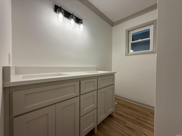 bathroom with wood finished floors, baseboards, and vanity