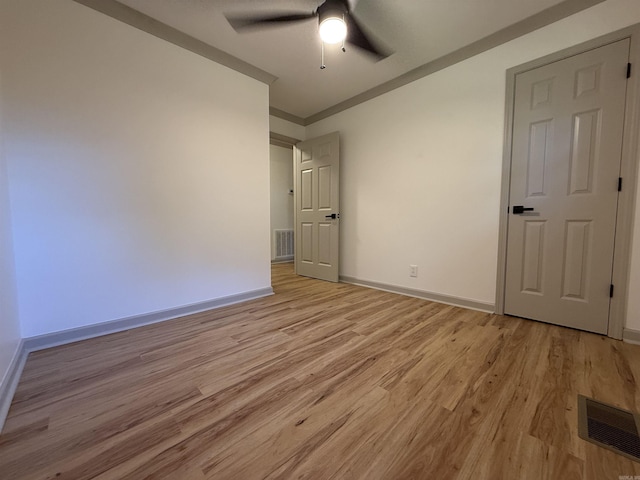 unfurnished bedroom with light wood-type flooring, baseboards, a ceiling fan, and crown molding