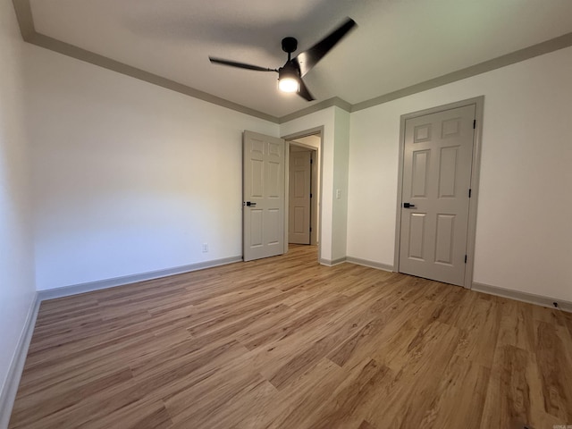 unfurnished bedroom with light wood-style flooring, baseboards, and a ceiling fan