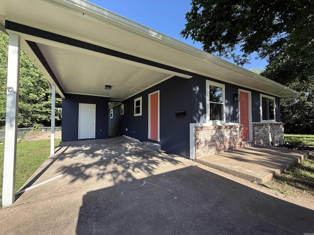 view of front of property featuring driveway, an attached carport, and brick siding