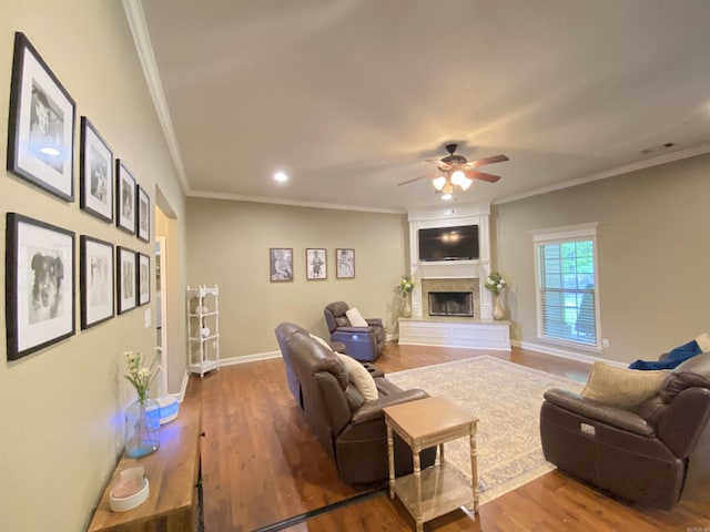 3008 Lilly Ln, Benton, AR 72019 - living room with crown molding, ceiling fan, wood finished floors, a fireplace with raised hearth, and baseboards