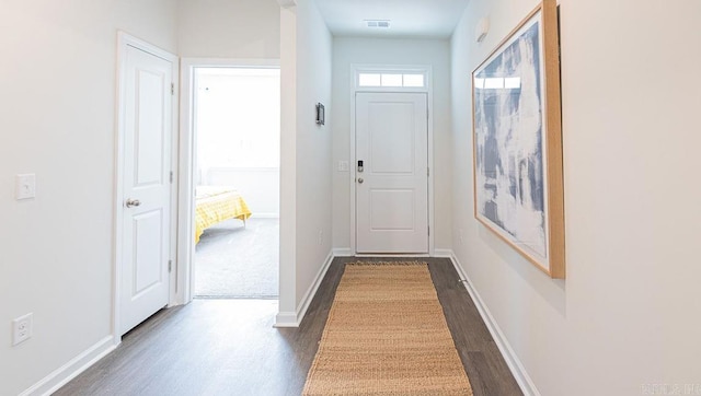doorway to outside with dark wood-style floors and baseboards