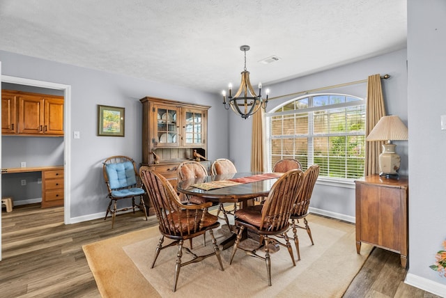 40 Pine Mountain Dr, Conway, AR 72034 - dining room featuring light wood-type flooring, a chandelier, baseboards, a textured ceiling, and a desk