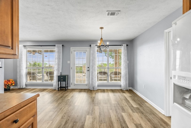 40 Pine Mountain Dr, Conway, AR 72034 - unfurnished dining area with a chandelier, light wood-style floors, a textured ceiling, and baseboards