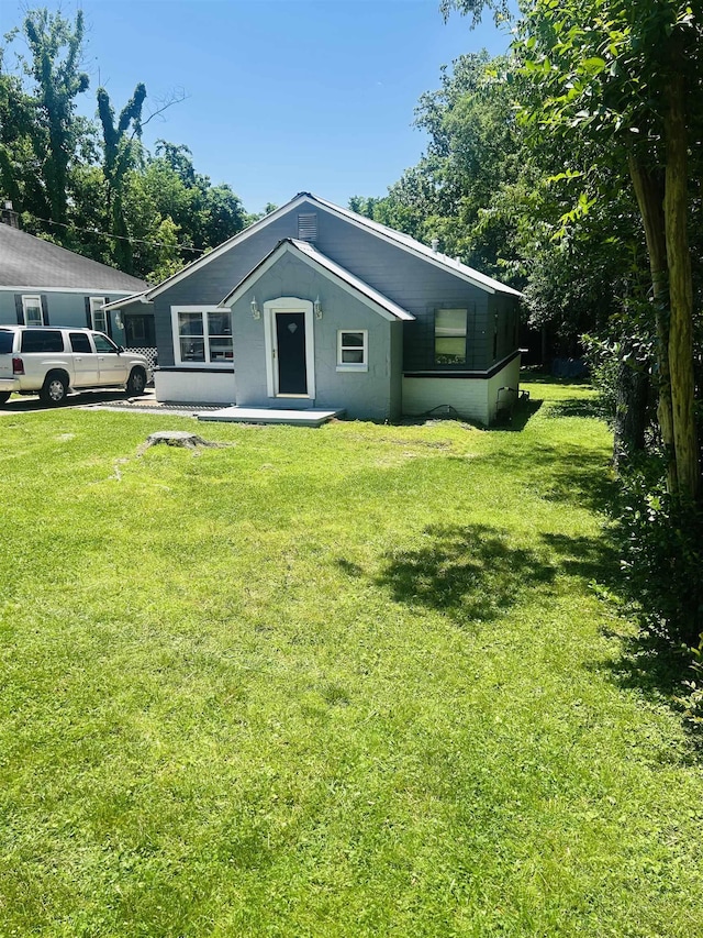 back of property featuring a yard