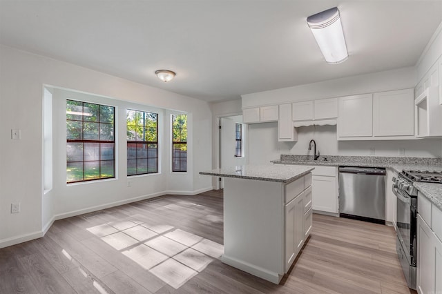 612 Briar St, Sherwood, AR 72120 - kitchen with stainless steel dishwasher, gas range oven, light wood-style flooring, and a center island