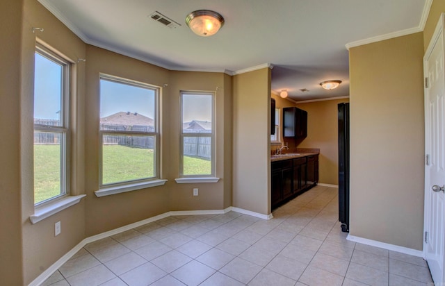9808 Lanehart Rd, Little Rock, AR 72204 - unfurnished dining area featuring plenty of natural light, crown molding, light tile patterned floors, a sink, and baseboards