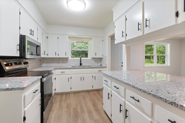 118 Blair St, Searcy, AR 72143 - kitchen with appliances with stainless steel finishes, a sink, tasteful backsplash, light wood finished floors, and white cabinetry