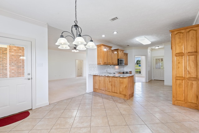 6 Donnie Cv, Greenbrier, AR 72058 - kitchen with stainless steel microwave, a chandelier, crown molding, light tile patterned flooring, and decorative backsplash