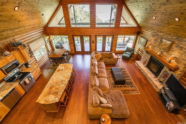 389 Tortoise Bay Rd, Higden, AR 72067 - living room featuring high vaulted ceiling, rustic walls, plenty of natural light, a fireplace, and wood finished floors
