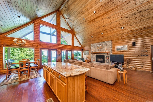 389 Tortoise Bay Rd, Higden, AR 72067 - kitchen featuring high vaulted ceiling, log walls, a chandelier, light stone countertops, and a fireplace
