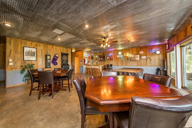 389 Tortoise Bay Rd, Higden, AR 72067 - dining area featuring wood walls, a ceiling fan, and finished concrete flooring
