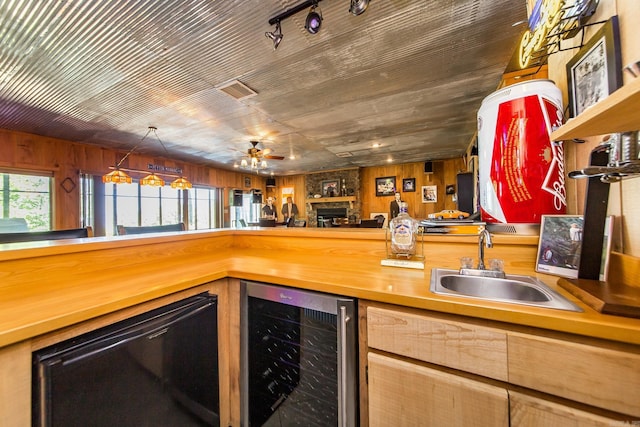 389 Tortoise Bay Rd, Higden, AR 72067 - indoor bar with wine cooler, ceiling fan, a fireplace, and wood walls