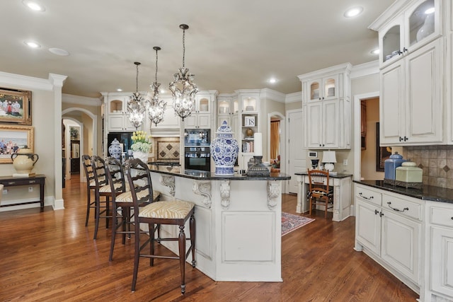 4 Dressage Ct, Little Rock, AR 72223 - kitchen with arched walkways, black appliances, recessed lighting, tasteful backsplash, and a breakfast bar