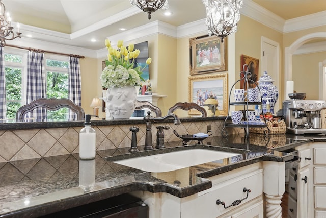 4 Dressage Ct, Little Rock, AR 72223 - kitchen with a sink, decorative backsplash, dark stone counters, white cabinetry, and crown molding
