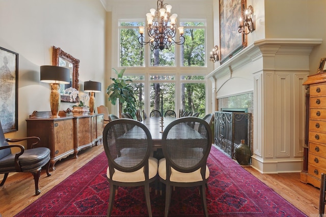 4 Dressage Ct, Little Rock, AR 72223 - dining space with a chandelier, light wood finished floors, a towering ceiling, a high end fireplace, and ornamental molding