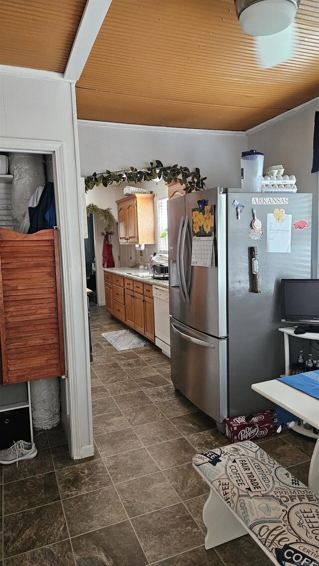 620 W 3rd St, Rector, AR 72461 - kitchen with dishwasher, stainless steel fridge, light countertops, brown cabinetry, and dark stone finish floors
