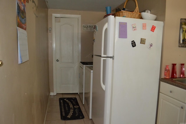 423 W Saint Louis St, Hot Springs, AR 71913 - kitchen featuring freestanding refrigerator, light tile patterned flooring, dark countertops, and white cabinetry