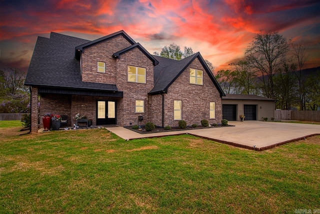 6020 Centark Ct, Alexander, AR 72002 - back of house at dusk with french doors, concrete driveway, a patio area, an attached garage, and brick siding