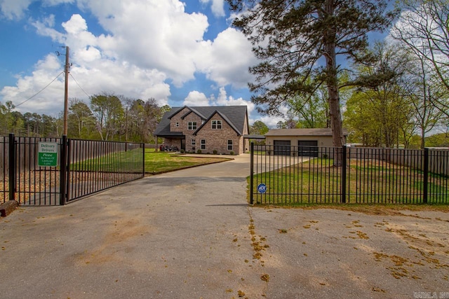 6020 Centark Ct, Alexander, AR 72002 - view of front facade with a gate, driveway, stone siding, and a detached garage