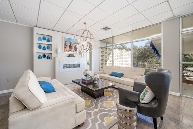 740 Weston Rd Unit 309-B, Hot Springs, AR 71913 - living area featuring healthy amount of natural light, a chandelier, a wall of windows, baseboards, and a drop ceiling