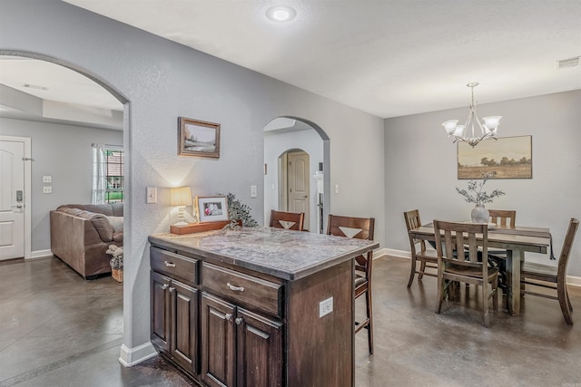 58 Eaglebrook Dr, Conway, AR 72032 - kitchen featuring concrete flooring, arched walkways, a kitchen bar, and a textured wall