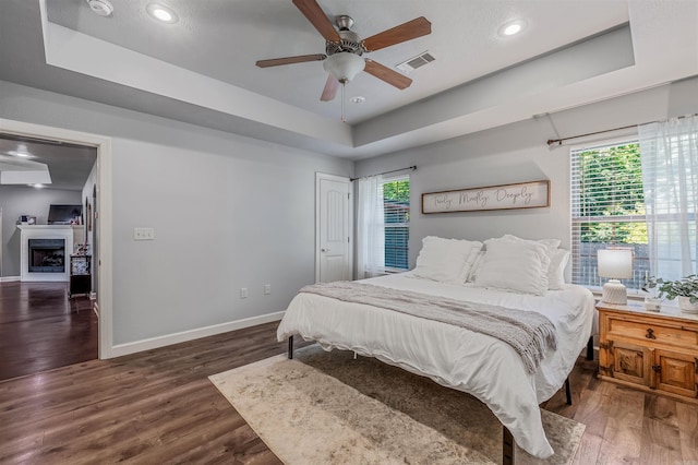 58 Eaglebrook Dr, Conway, AR 72032 - bedroom with a tray ceiling, wood finished floors, baseboards, multiple windows, and recessed lighting