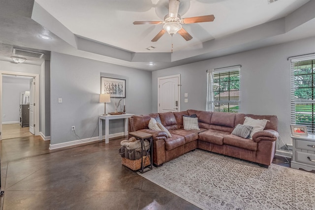58 Eaglebrook Dr, Conway, AR 72032 - living room featuring a raised ceiling, concrete floors, baseboards, a ceiling fan, and plenty of natural light