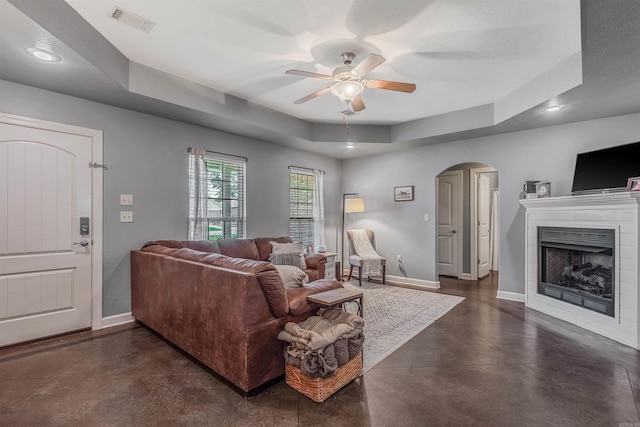 58 Eaglebrook Dr, Conway, AR 72032 - living area with arched walkways, a ceiling fan, baseboards, a tray ceiling, and recessed lighting
