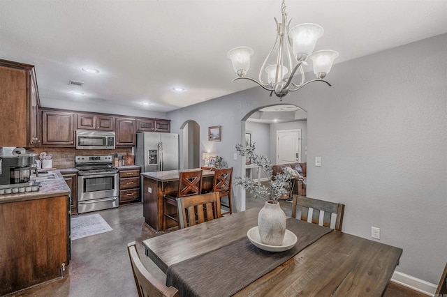 58 Eaglebrook Dr, Conway, AR 72032 - dining space with arched walkways, finished concrete floors, a chandelier, baseboards, and recessed lighting