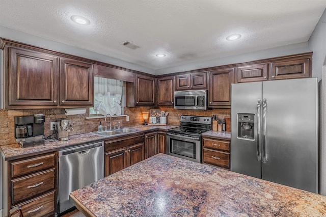58 Eaglebrook Dr, Conway, AR 72032 - kitchen featuring appliances with stainless steel finishes, a sink, backsplash, dark brown cabinets, and recessed lighting