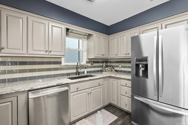 2 Timber Ridge Ct, Little Rock, AR 72211 - kitchen featuring stainless steel appliances, a sink, backsplash, dark wood-type flooring, and a textured ceiling