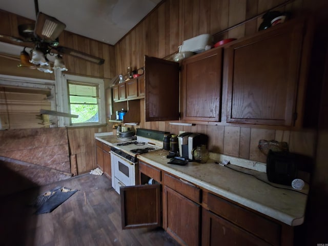 1609 W Charles Bussey Ave, Little Rock, AR 72202 - kitchen with gas range gas stove, wood walls, ceiling fan, dark wood-type flooring, and light countertops