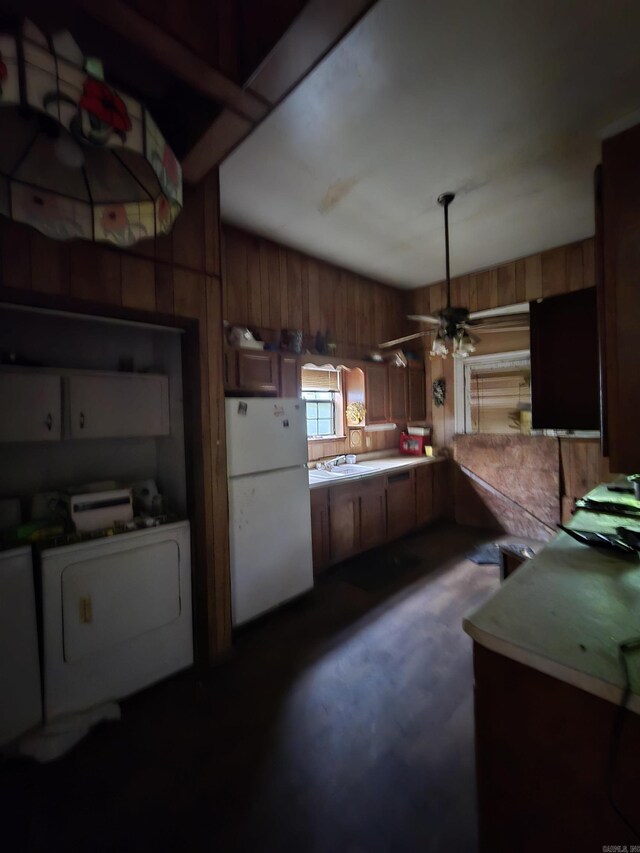 1609 W Charles Bussey Ave, Little Rock, AR 72202 - kitchen with freestanding refrigerator, washer / dryer, ceiling fan, a sink, and wood walls