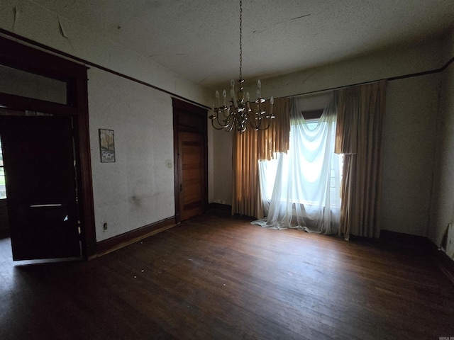 1609 W Charles Bussey Ave, Little Rock, AR 72202 - unfurnished dining area with a chandelier, wood finished floors, healthy amount of natural light, baseboards, and a textured ceiling