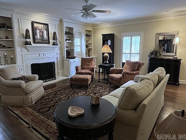 2111 Hinson Rd Unit 19, Little Rock, AR 72212 - living area featuring a large fireplace, crown molding, a ceiling fan, wood finished floors, and built in features