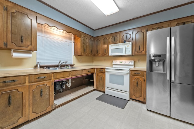 104 Heatherbrae Ct, Sherwood, AR 72120 - kitchen with white appliances, a sink, a textured ceiling, light flooring, and brown cabinetry