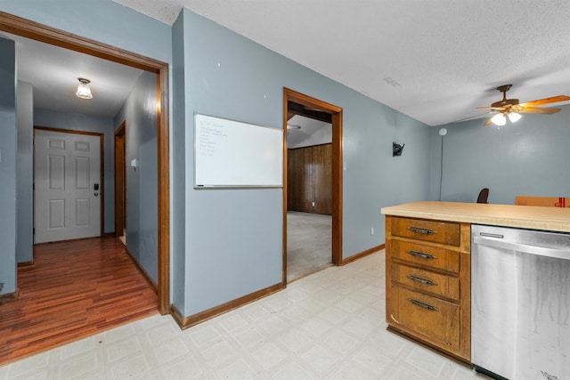 104 Heatherbrae Ct, Sherwood, AR 72120 - kitchen featuring dishwasher, light flooring, a ceiling fan, baseboards, and a textured ceiling