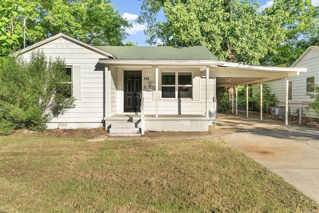 713 Hyacinth St, North Little Rock, AR 72117 - view of front facade with driveway, a front lawn, an attached carport, a shingled roof, and a porch