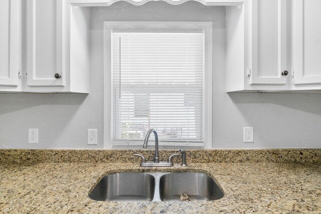 713 Hyacinth St, North Little Rock, AR 72117 - kitchen featuring a sink, white cabinetry, and light stone counters